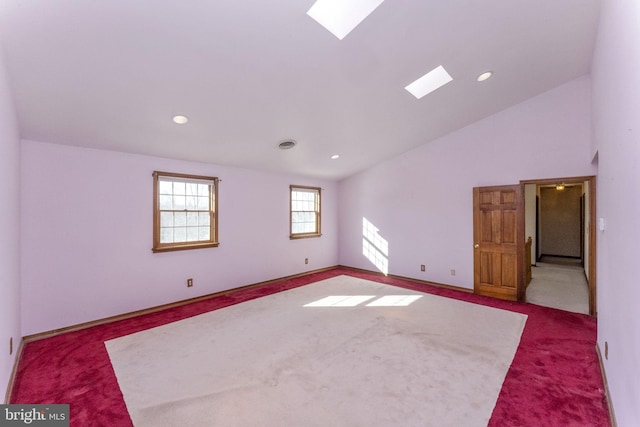 carpeted spare room with lofted ceiling with skylight