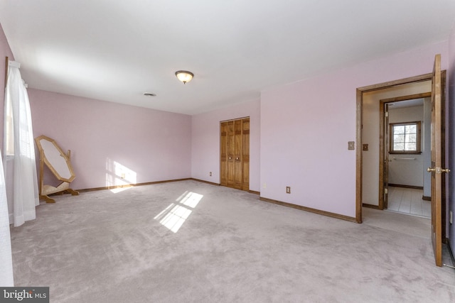 unfurnished bedroom featuring light carpet and a closet