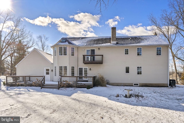 snow covered property featuring cooling unit and a balcony