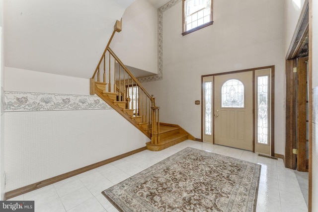 tiled entrance foyer featuring a high ceiling