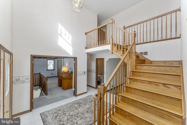 staircase featuring a towering ceiling