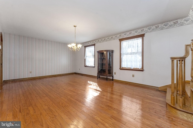 unfurnished room featuring light hardwood / wood-style floors and a notable chandelier