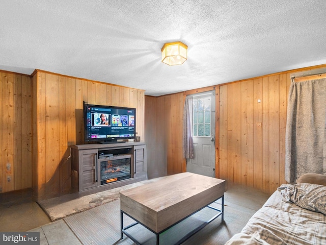 living room with wood walls and a textured ceiling