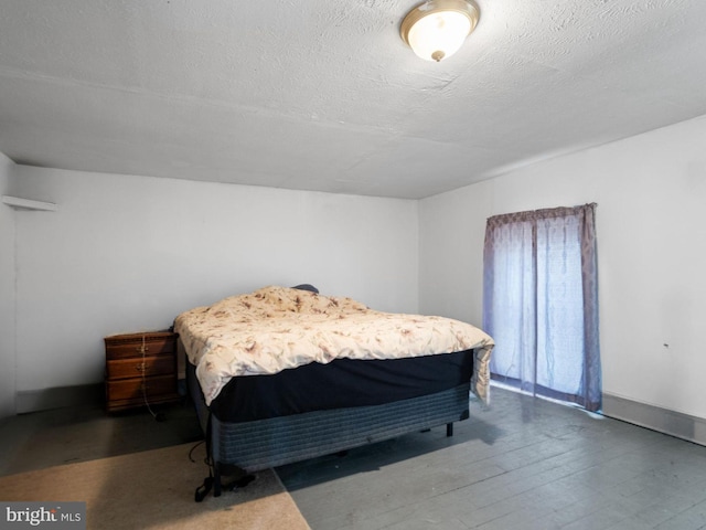 bedroom with a textured ceiling and hardwood / wood-style flooring