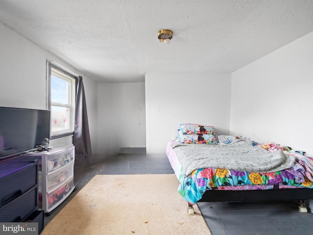 bedroom featuring a textured ceiling and concrete floors