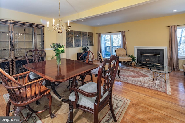 dining area featuring light wood-type flooring and an inviting chandelier