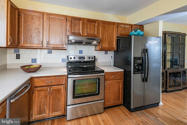 kitchen featuring backsplash, light hardwood / wood-style flooring, and stainless steel appliances