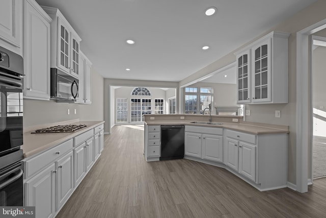 kitchen with white cabinetry, sink, and black dishwasher