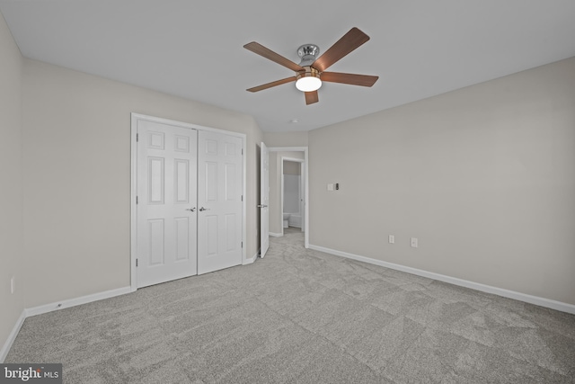 unfurnished bedroom with ceiling fan, a closet, and light colored carpet