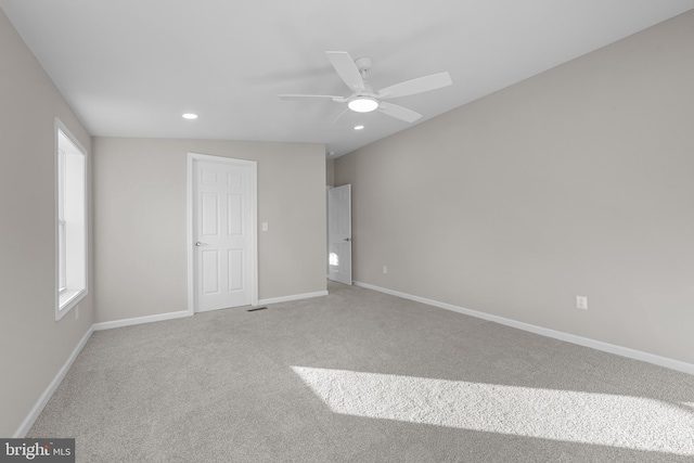 unfurnished bedroom featuring carpet flooring, multiple windows, ceiling fan, and vaulted ceiling