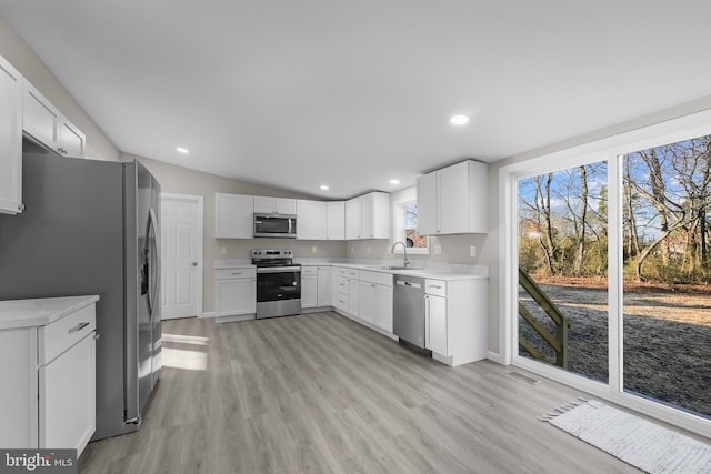 kitchen featuring white cabinets, lofted ceiling, and stainless steel appliances