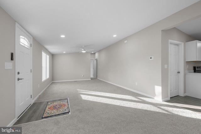 carpeted foyer featuring vaulted ceiling and ceiling fan