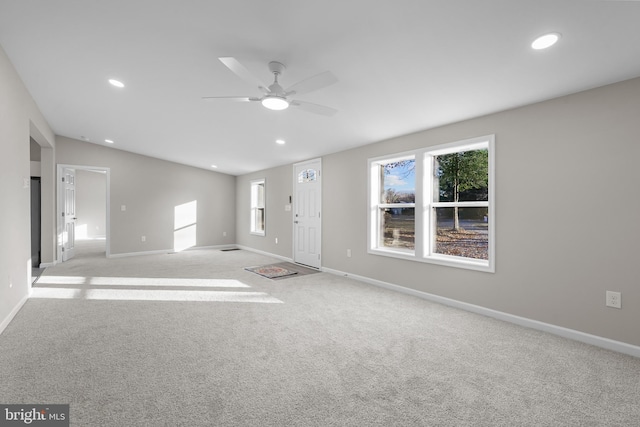 unfurnished living room featuring light carpet and ceiling fan