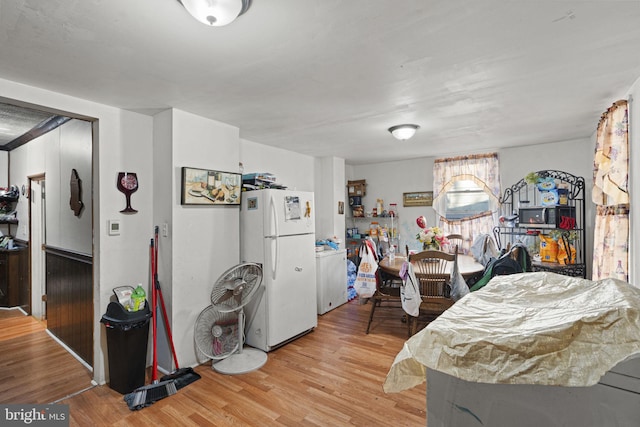 interior space featuring washer / clothes dryer, light hardwood / wood-style flooring, and white fridge