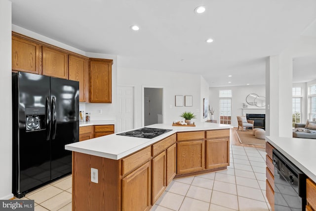 kitchen featuring light tile patterned floors, black appliances, and a kitchen island