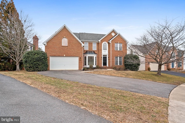 view of front of house featuring a front lawn and a garage