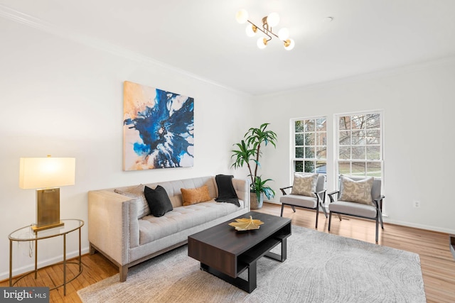 living room featuring hardwood / wood-style flooring, crown molding, and an inviting chandelier