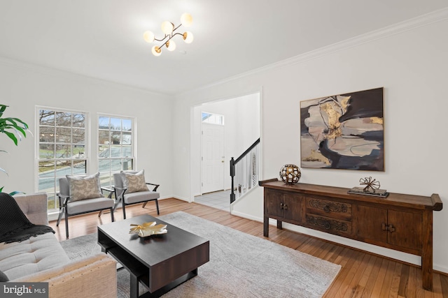 living room with crown molding, an inviting chandelier, and wood-type flooring