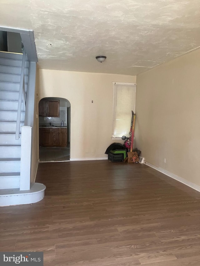 spare room featuring dark hardwood / wood-style flooring and a textured ceiling