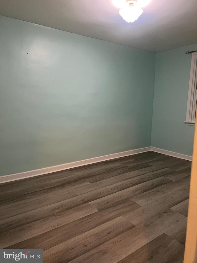 spare room with dark hardwood / wood-style flooring