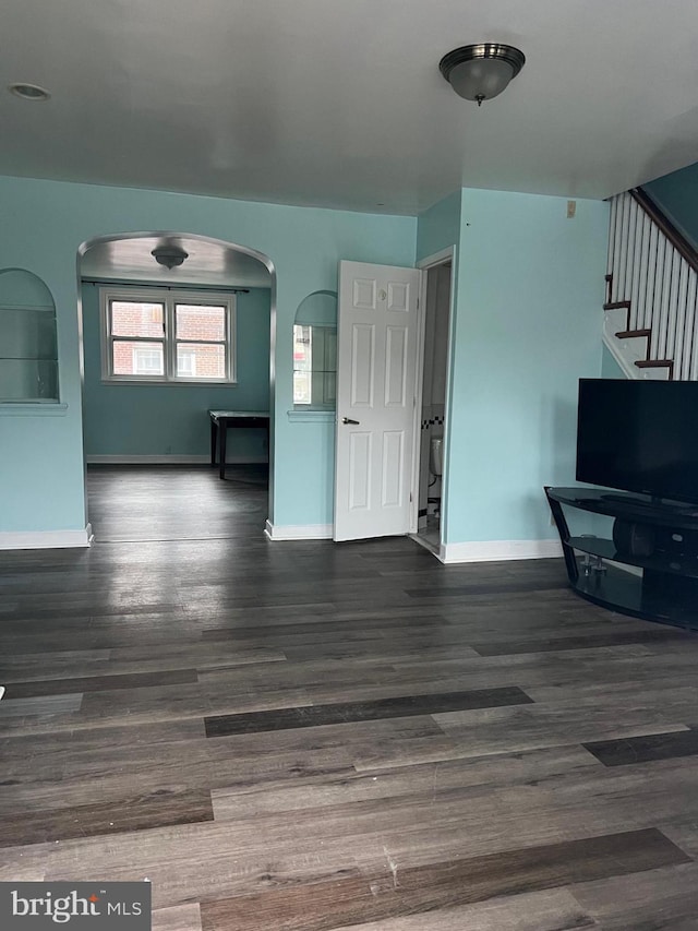 unfurnished living room featuring dark wood-type flooring