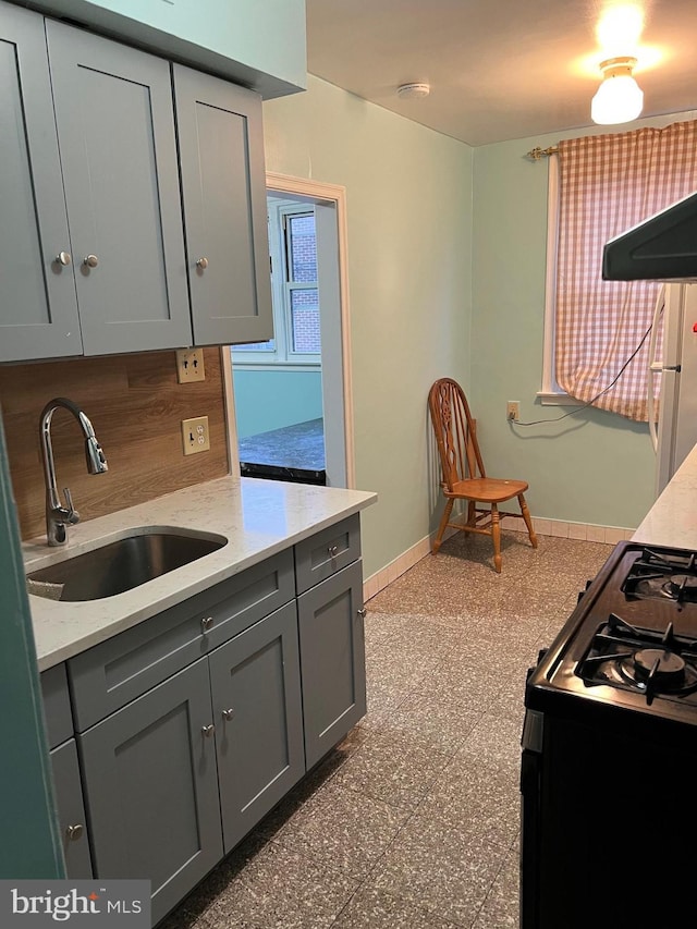 kitchen with gray cabinets, sink, white fridge, and range