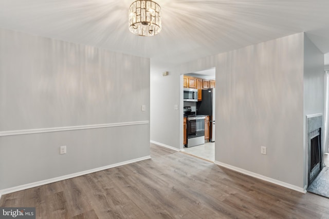 unfurnished living room featuring light hardwood / wood-style flooring and a chandelier