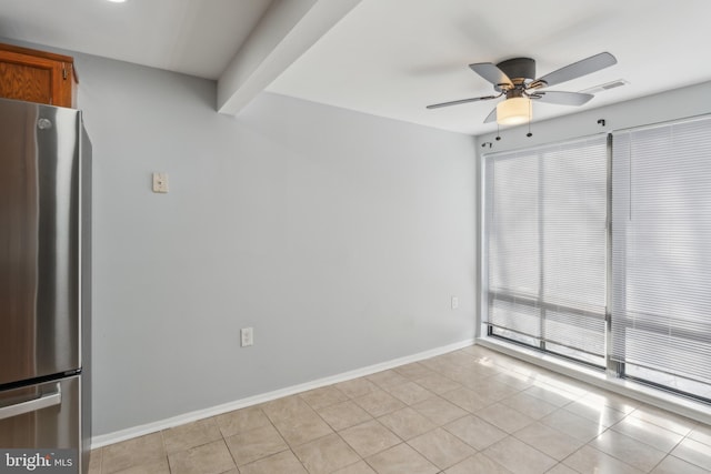 tiled spare room featuring beam ceiling and ceiling fan