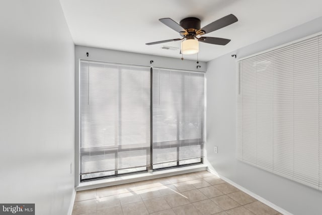 tiled empty room with ceiling fan