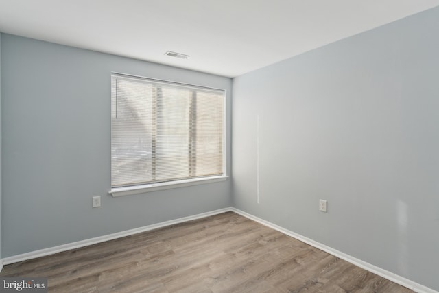 spare room with a wealth of natural light and light hardwood / wood-style flooring