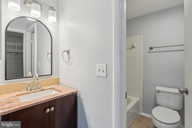 full bathroom with tiled shower / bath, vanity, and toilet