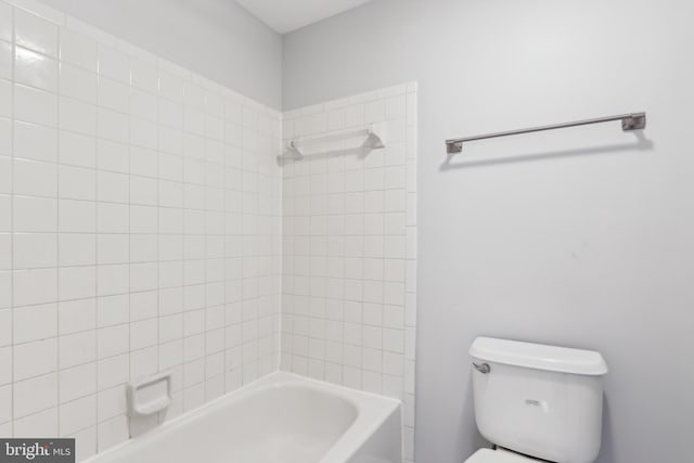 bathroom featuring tiled shower / bath and toilet