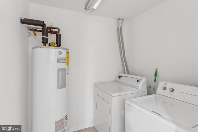 clothes washing area with electric water heater and separate washer and dryer