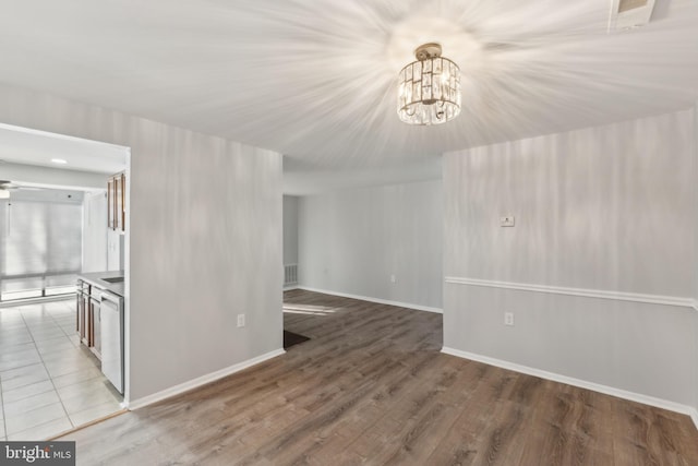 unfurnished room featuring wood-type flooring and a notable chandelier