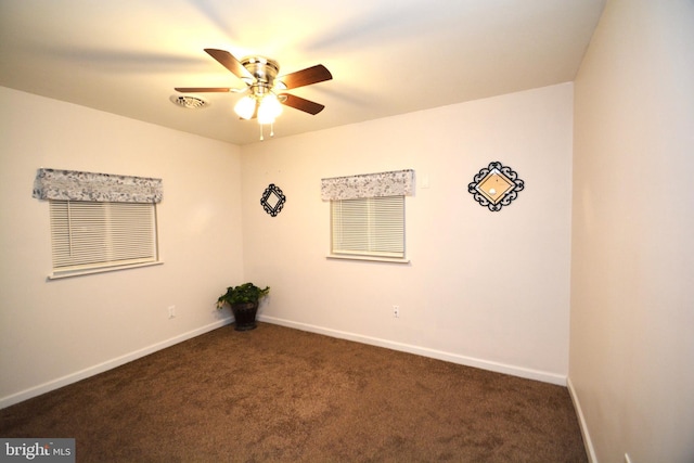 unfurnished room with dark colored carpet and ceiling fan