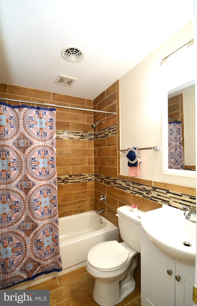 full bathroom featuring vanity, toilet, shower / bath combo with shower curtain, tile walls, and tasteful backsplash