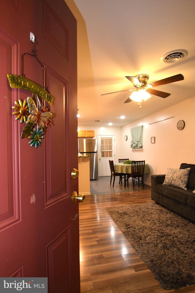 living room with ceiling fan and dark hardwood / wood-style flooring