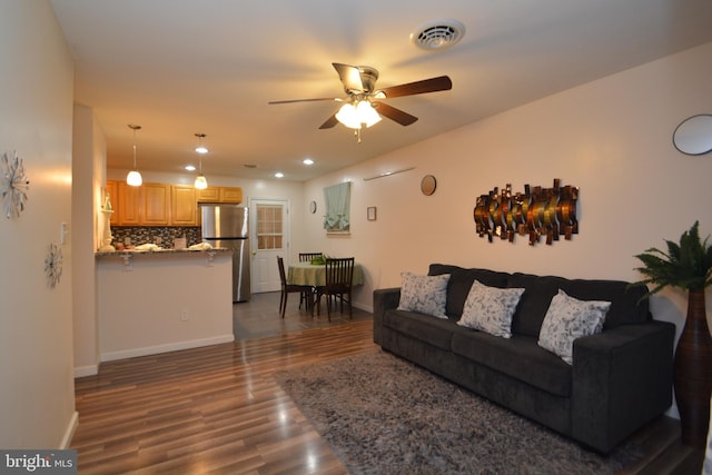 living room with ceiling fan and dark wood-type flooring