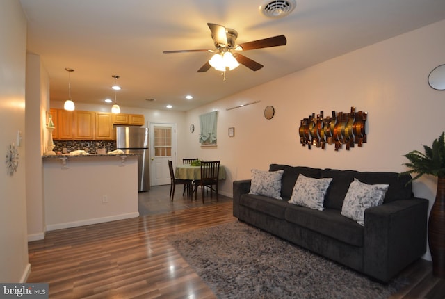 living room with ceiling fan and dark wood-type flooring