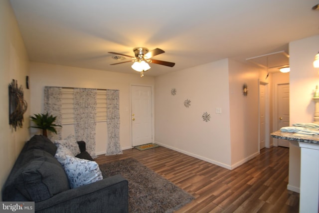 living room with ceiling fan and dark wood-type flooring