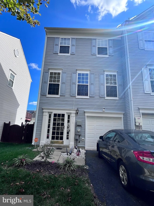 view of front facade featuring aphalt driveway, fence, and a garage