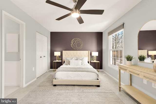 carpeted bedroom featuring ceiling fan and a closet