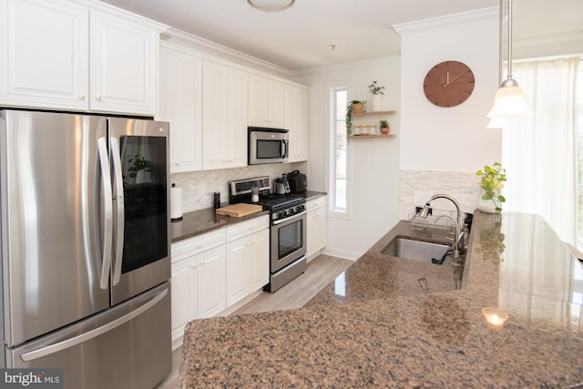 kitchen with white cabinetry, stainless steel appliances, dark stone counters, decorative backsplash, and sink