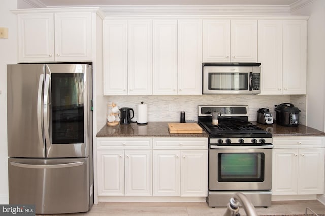 kitchen featuring white cabinetry, appliances with stainless steel finishes, and tasteful backsplash