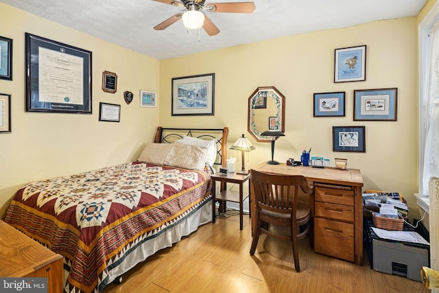 bedroom with a textured ceiling, light wood-type flooring, and ceiling fan