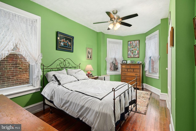 bedroom with radiator heating unit, a textured ceiling, dark hardwood / wood-style floors, and ceiling fan