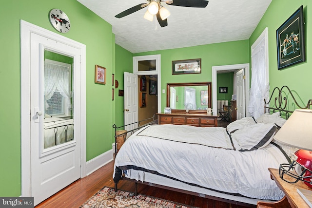 bedroom with ceiling fan, hardwood / wood-style floors, and a textured ceiling