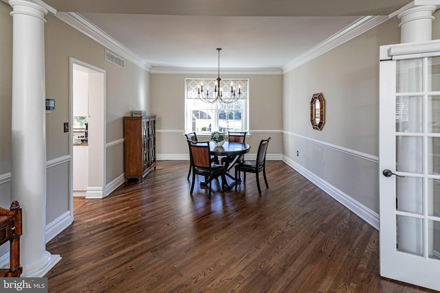 dining room with ornate columns, dark wood-type flooring, a chandelier, and ornamental molding