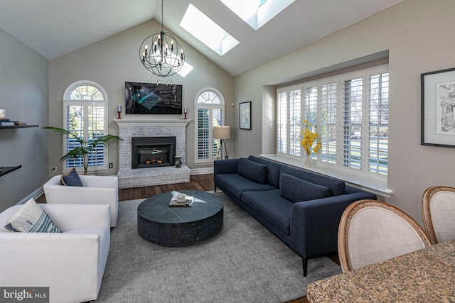 living room featuring a fireplace, a chandelier, vaulted ceiling, and hardwood / wood-style flooring