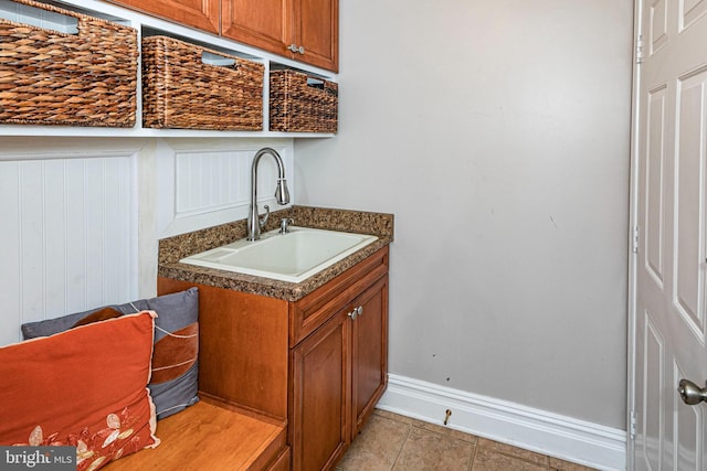 laundry area with light tile patterned floors and sink